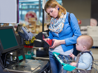 Femme soucieuse à la caisse d'un magasin